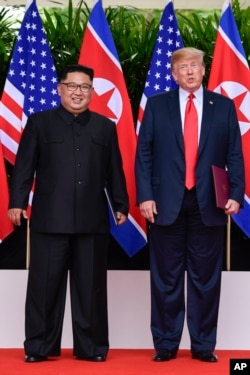 North Korea leader Kim Jong Un and U.S. President Donald Trump stand side by side before their departures after meeting at the Capella resort on Sentosa Island Tuesday, June 12, 2018 in Singapore. (AP Photo/Susan Walsh, Pool)