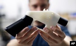 Cody Wilson, with Defense Distributed, holds a 3-D-printed gun called the Liberator at his shop in Austin, Texas, Aug. 1, 2018.