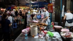 Jirintat, and Adulwitch Tangsupmanee, 42, son and daughter of Chanchai Tangsupmanee, who died at age 73 of the coronavirus disease in July, works at their late father's food stall in Bangkok's Chinatown, Thailand, October 6, 2021. (REUTERS)