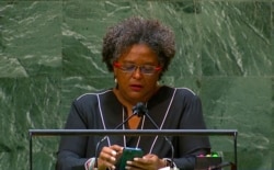 Mia Amor Mottley, prime minister of Barbados, reads from her phone as she addresses the 76th Session of the U.N. General Assembly at U.N. headquarters, Sept. 24, 2021.