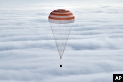 Russia’s Soyuz TMA-18M space capsule carrying the International Space Station (ISS) crew members prepares to land in a remote area outside the town of Dzhezkazgan, Kazakhstan, Wednesday, March 2, 2016.