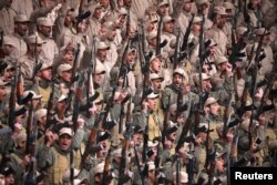 Fighters from the self-defence forces of the Kurdish-led north hold their weapons during a rally in Hasaka, northeastern Syria, Jan. 23, 2018.