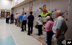 FILE - People line up to vote inside a precinct in Matthews, N.C., Tuesday, March 15, 2016.
