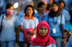 Seorang pekerja pabrik sepatu pulang kerja sepulang kerja, di kawasan industri Pasar Kemis di Tangerang, 13 Agustus 2014. (Foto: AP)