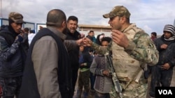 Soldiers explain security procedures intended to catch any militants trying to flee with families as they arrive at camps outside of Mosul on March 19, 2017 in Hammam Aleel, Iraq. (H.Murdock/VOA)