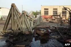 Workers inspect damages at the site of an air strike on the maintenance hub at the Hodeidah port, on May 27, 2018.