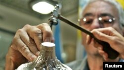 FILE - Argentine silversmith Juan Carlos Pallarols, seen in May 2005 carving a chalice for Pope Benedict XVI, is in the middle of a spat between Argentina's outgoing president and president elect.