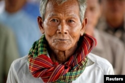 FILE - Sok Teng, 73, waits with other survivors and relatives of victims of the Khmer Rouge regime to enter the Extraordinary Chambers in the Courts of Cambodia (ECCC) to attend the delivery of verdict in the trial of former Khmer Rouge head of state Khieu Samphan and former Khmer Rouge leader ''Brother Number Two'' Nuon Chea on the outskirts of Phnom Penh Aug. 7, 2014.
