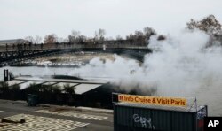 Tear gas is thrown along the Seine River banks during a protest in Paris, Jan. 5, 2019. Hundreds of protesters were trying to breathe new life into France's apparently waning yellow vest movement with marches in Paris and gatherings in other cities.