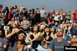 People watch the solar eclipse on the lawn of Griffith Observatory in Los Angeles, California, U.S., August 21, 2017.