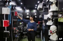 An Indian woman looks for air pollution mask inside a shop in New Delhi, India, Nov. 4, 2016. A new report from UNICEF says about a third of the 2 billion children in the world who are breathing toxic air live in northern India and neighboring countries.