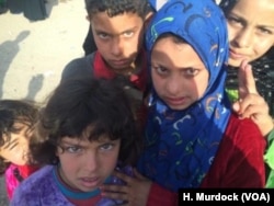 Children from New Mosul, an area that has seen mass civilian casualties, say they saw people shot and killed by IS militants as they ran away, March 29, 2017, in Hammam Alil, Iraq.