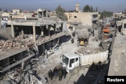 Residents inspect damage at a site hit by one of three explosive trucks, in the YPG-controlled town of Tel Tamer, Syria, Dec. 11, 2015.