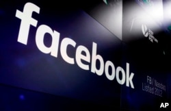FILE- The logo for Facebook appears on screens at the Nasdaq MarketSite in New York's Times Square, In this March 29, 2018 photo.