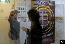 People use a Bitcoin ATM in Hong Kong, Friday, Dec. 8, 2017.