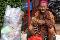 Seorang perempuan pemulung di pinggiran jalan di Jakarta, 29 Mei 2020. (Foto: AFP)