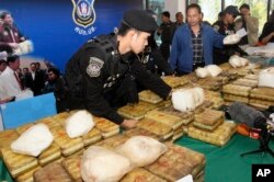 FILE - Thai policemen arrange packages of methamphetamine on a table before a press conference in Bangkok, Thailand, Feb. 15, 2013.