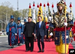 North Korean leader Kim Jong Un, left, and South Korean President Moon Jae-in walk together at the border village of Panmunjom in the Demilitarized Zone, April 27, 2018.