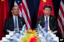 FILE - President Barack Obama, left, meets with Chinese President Xi Jinping outside Paris, Nov. 30, 2015.