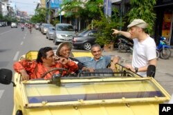 Sutradara "The Act of Killing" Joshua Oppenheimer (kanan) berbicara dengan tokoh utama filmnya, Anwar Congo (kedua dari kiri, memakai topi). (AP/Drafthouse Films)