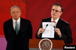 Mexico's Foreign Minister Marcelo Ebrard holds a document as Mexico's President Andres Manuel Lopez Obrador looks on during a news conference at the National Palace in Mexico City, Mexico, June 10, 2019.