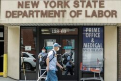Pejalan kaki melewati kantor Departemen Tenaga Kerja di New York, 11 Juni 2020.