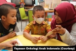 Seorang relawan Yayasan Onkologi Anak Indonesia (YOAI) bermain bersama anak-anak yang sedang menjalani perawatan kanker, September 2019. (Foto: Yayasan Onkologi Anak Indonesia)