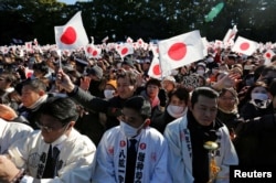 Warga mengibarkan bendera nasional Jepang dan meneriakkan 'Banzai' saat Kaisar Jepang Akihito dan anggota keluarga kerajaannya hadir dalam perayaan Tahun Baru di Istana Kekaisaran di Tokyo, Jepang, 2 Januari 2019. mengibarkan bendera dan meneriakkan 'Banzai' atau sorakan selama penampilan Kaisar Jepang Akihito dan anggota keluarga kerajaannya untuk perayaan Tahun Baru di Istana Kekaisaran di Tokyo, Jepang, 2 Januari 2019.
