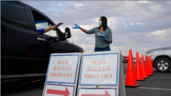 Një punonjëse e bashkisë mbledh votat me postë në një zonë të caktuar për njerëzit që dorëzojnë votën nga makina (Qarku Clark, Las Vegas, 2 nëntor 2020)