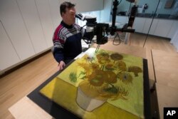 Pakar konservasi lukisan, Rene Boitelle, sedang merestorasi lukisan "Bunga Matahari", karya terkenal pelukis Vincent van Gogh di Museum Van Gogh di Amsterdam, Belanda, 23 Januari 2019.(Foto: Reuters)
