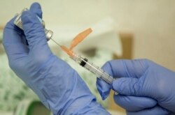 FILE - A nurse practitioner prepares a flu vaccination in Rockville, Maryland, Aug. 27, 2010.