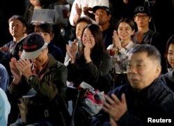 Fans of the Japanese writer Haruki Murakami celebrate after they heard that Japanese-born Kazuo Ishiguro won the Nobel Prize for Literature while they gather in a shrine with the hope of celebrating Murakami's winning in the prize in Tokyo, Japan, Oct. 5,