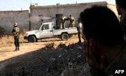 Fighters from the Free Syrian Army fire a machine gun mounted on a vehicle deployed during fighting against Islamic State group jihadists on the outskirts of the northern Syrian town of Dabiq, Oct. 15, 2016.