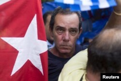 A supporter of the Ladies in White dissident group looks on as he is detained by Cuban security personnel during a protest on International Human Rights Day, Havana, December 10, 2015.
