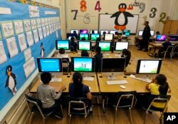 FILE - Elementary students work on computers in Los Angeles, May 15, 2012.