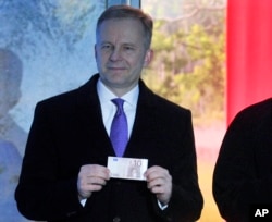 FILE - Governor of Bank of Latvia Ilmars Rimsevics holds a euro note in Riga, Latvia, Feb. 18, 2018.