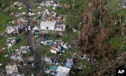 FILE - In this Sept. 28, 2017, photo, damaged and destroyed homes are seen in the aftermath of Hurricane Maria in Toa Alta, Puerto Rico.