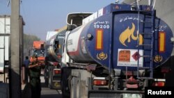 A member of Palestinian security forces gestures as a fuel tanker arrives at Kerem Shalom crossing in Rafah in the southern Gaza Strip, Aug. 15, 2018.