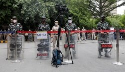 Petugas keamanan berjaga di lokasi aksi duduk petani yang memprotes undang-undang pertanian, dekat gedung parlemen, di New Delhi, India, 22 Juli 2021. (REUTERS/Adnan Abidi)