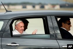 Paus Fransiskus melambai dari Fiat 500L sementara iring-iringan mobil meninggalkan Pangkalah Udara Andrews, Maryland, Selasa, 22 September 2015.