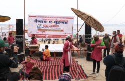 A local citizen peace campaigner group conducts a musical program with a message of communal harmony at a Varanasi ghat, Jan. 8, 2022, two days after right-wing Hindu groups put up posters warning non-Hindus to stay away from the ghats. (Praveen Joshi/VOA)