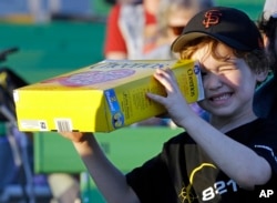 Griffin O'Roak watches the rising sun with his homemade eclipse viewer at a gathering of eclipse viewers in Salem, Ore., Monday, Aug. 21, 2017. (AP Photo/Don Ryan)
