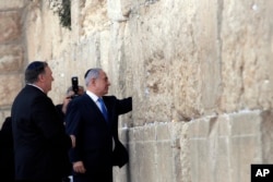 Israeli Prime Minister Benjamin Netanyahu, accompanied by U.S. Secretary of State Mike Pompeo, touches the stones of the Western Wall during Pompeo's visit to the site in Jerusalem's Old City, March 21, 2019.
