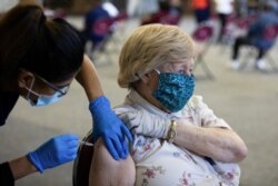 Seorang pasien menerima booster vaksin COVID-19 mereka selama klinik vaksinasi Pfizer-BioNTech di Southfield, Michigan, AS, 29 September 2021. (REUTERS/Emily Elconin)