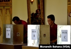 Gubernur DIY Sultan Hamengkubuwono X (kiri) dan permaisuri GKR Hemas (kanan) sedang melakukan pencoblosan di PTS 15 Kelurahan Panembahan, Kecamatan Kraton Yogyakarta, Rabu (17/4). (Foto: VOA/Munarsih Sahana).