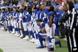 FILE - New York Giants defensive end Olivier Vernon kneels as the Giants stand for the national anthem before an NFL football game against the Washington Redskins Dec. 31, 2017, in East Rutherford, N.J.