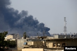 FILE - Smoke rises from from the old city during a battle against Islamic State militants, in Mosul, Iraq, March 24, 2017.