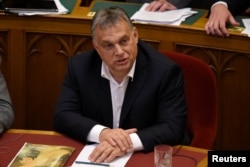 FILE - Hungarian Prime Minister Viktor Orban sits before vote on the 'Stop Soros' package of bills that criminalises some help given to illegal immigrants at the Parliament in Budapest, Hungary, June 20, 2018.