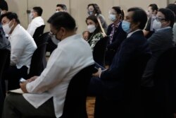 Anggota parlemen Filipina mengenakan masker saat menghadiri sidang sebelum pengambilan sumpah jabatan Lord Allan Velasco sebagai Ketua DPR di klub olahraga Celebrity di kota Quezon, Filipina, Senin, 12 Oktober 2020.