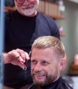Norway's Minister of Health, Bent Hoie Abid Raja gets his hair cut by hair dresser Morten Johansen, as hair dressers reopened after being closed down for more than six weeks in an effort to avoid spreading fo the COVID-19 Coronavirus, in Oslo, Norway.